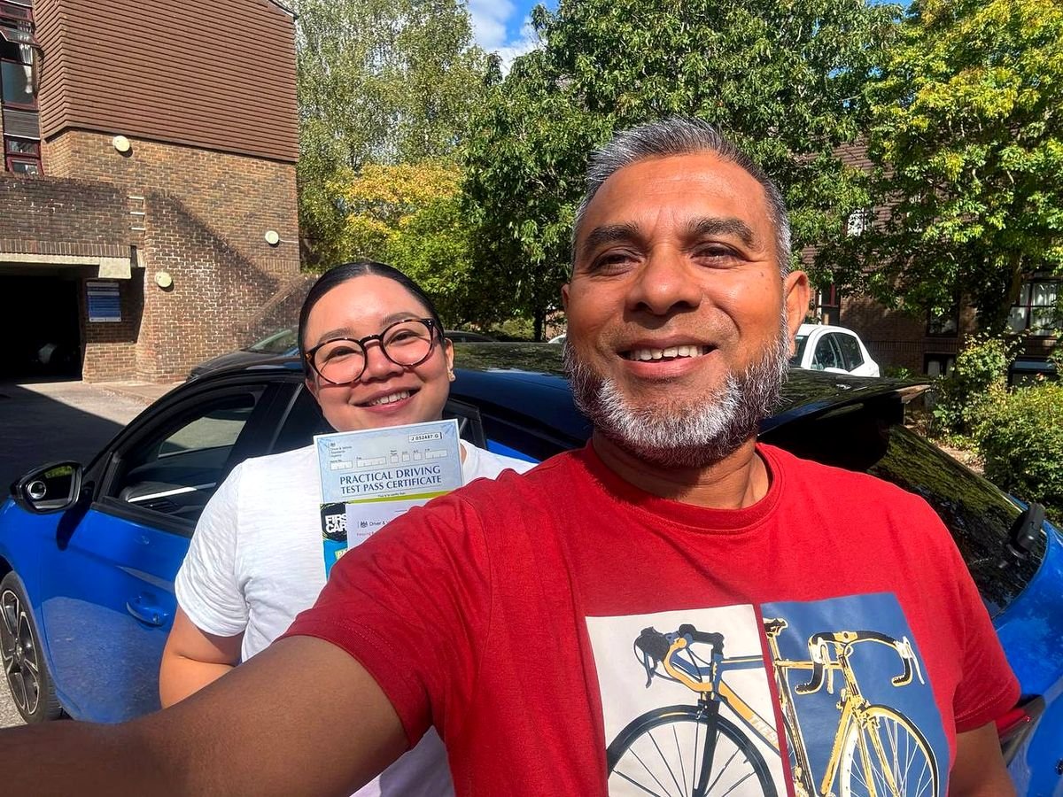 Syed with a pupil holding their driving test pass certificate